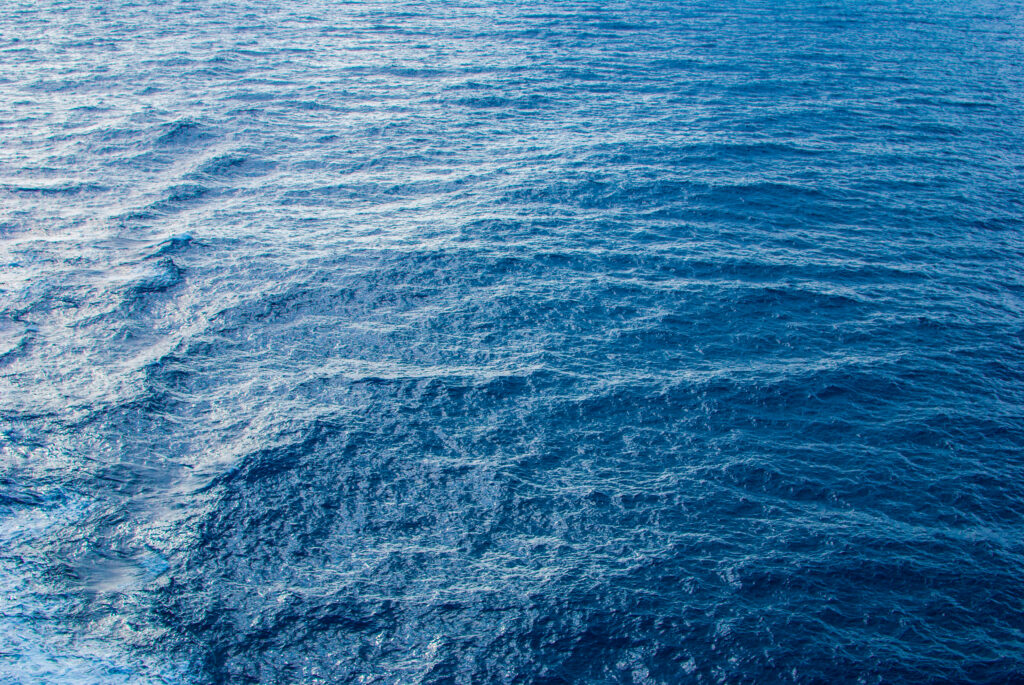 Serene deep blue ocean wallpaper with gentle ripples capturing calm endless sea expanse