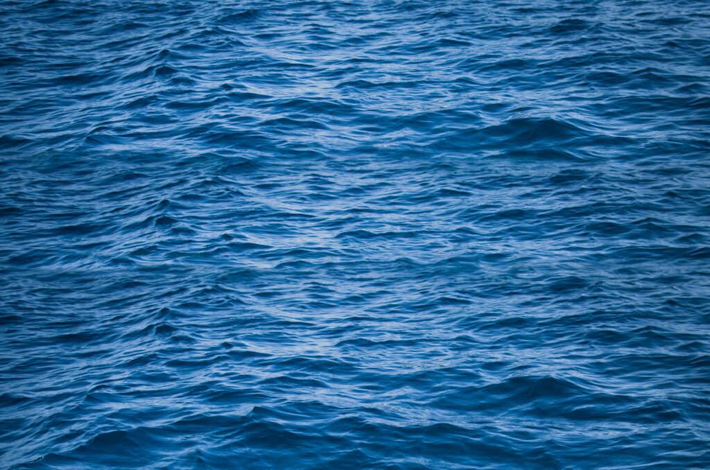 Serene deep blue sea wallpaper with gentle rippling waves creating a calming ocean texture