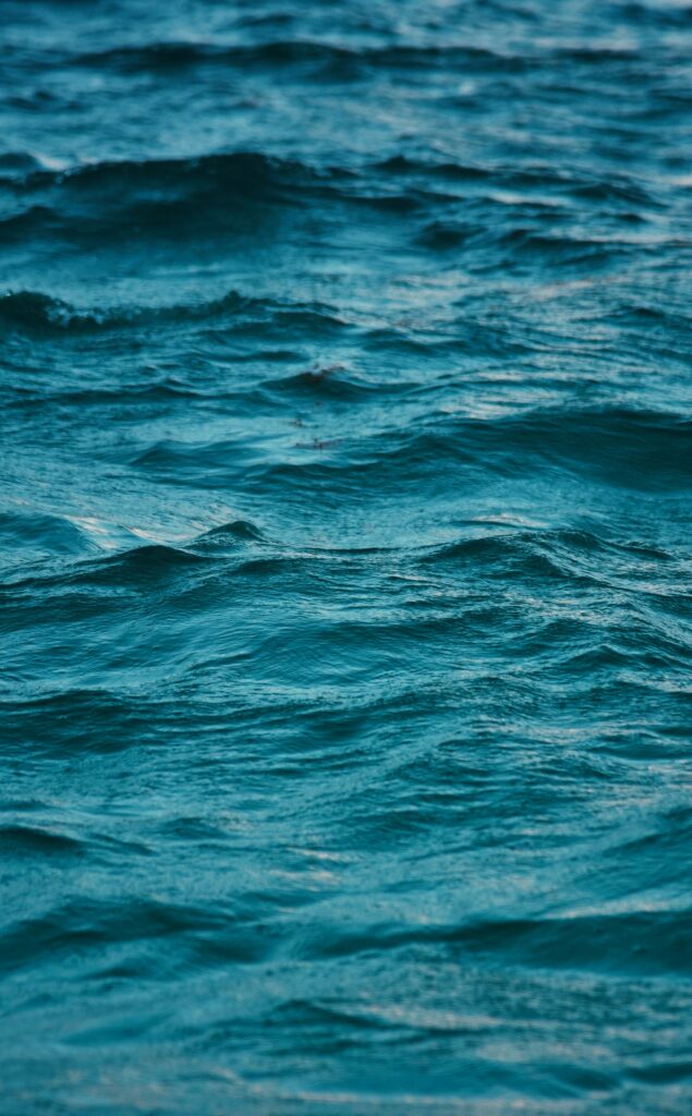 Serene deep blue sea wallpaper with gentle ripples soft waves and calming minimalist blur effect background