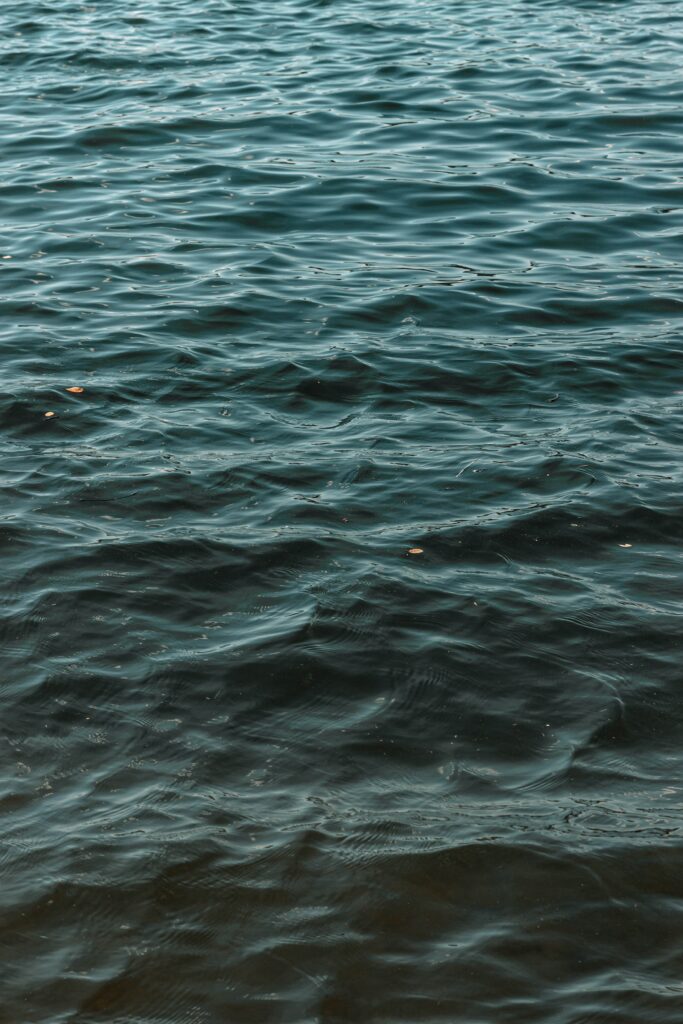 Calm water wallpaper with gentle blue and teal waves and soothing ripples for serene background