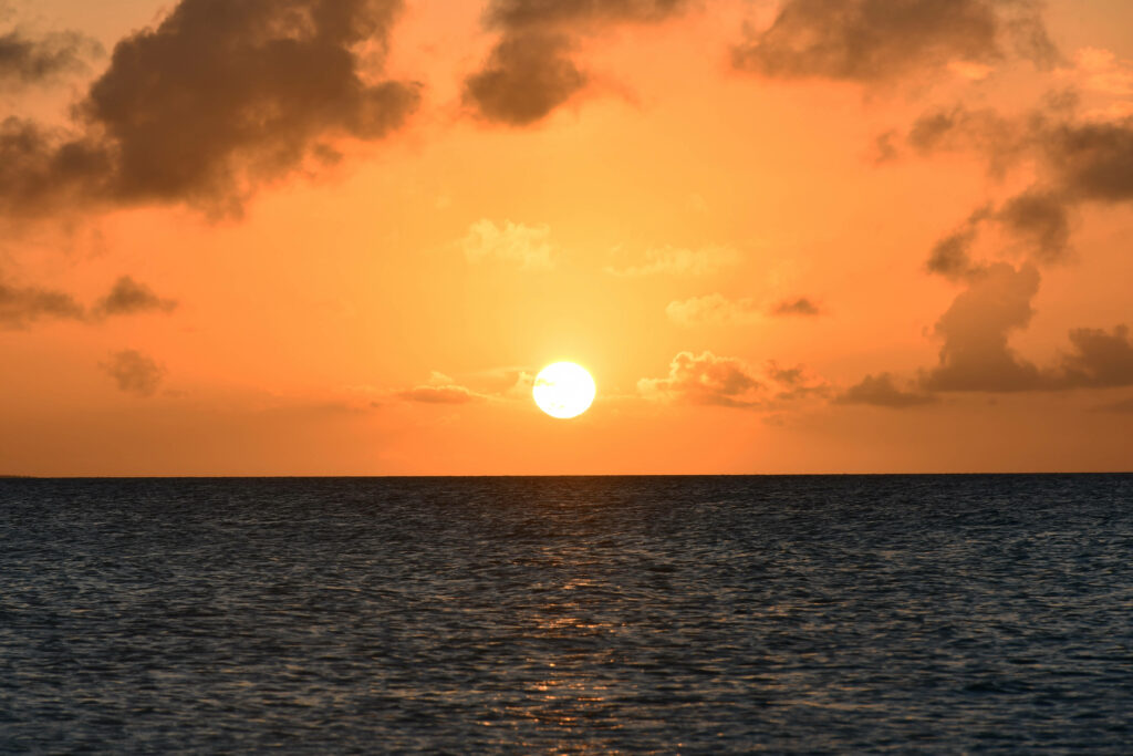 A Serene Venezualan Seascape: Marvelous Sunset Painting the Sky in Shades of Orange Wallpaper