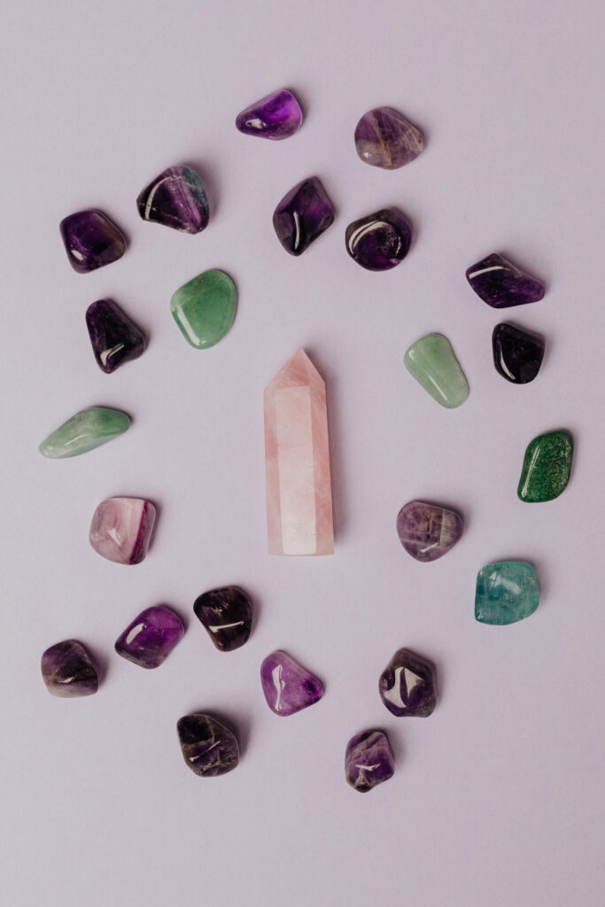 Shiny amethyst and colorful crystals arranged in a circle around polished rose quartz on lavender background Wallpaper