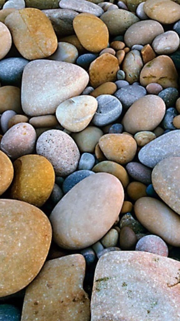 High-resolution photo of smooth rounded beige tan and gray beach stones minimalist wallpaper background
