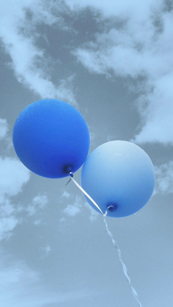 Two blue balloons floating gently against soft cloudy sky calming iPhone wallpaper background