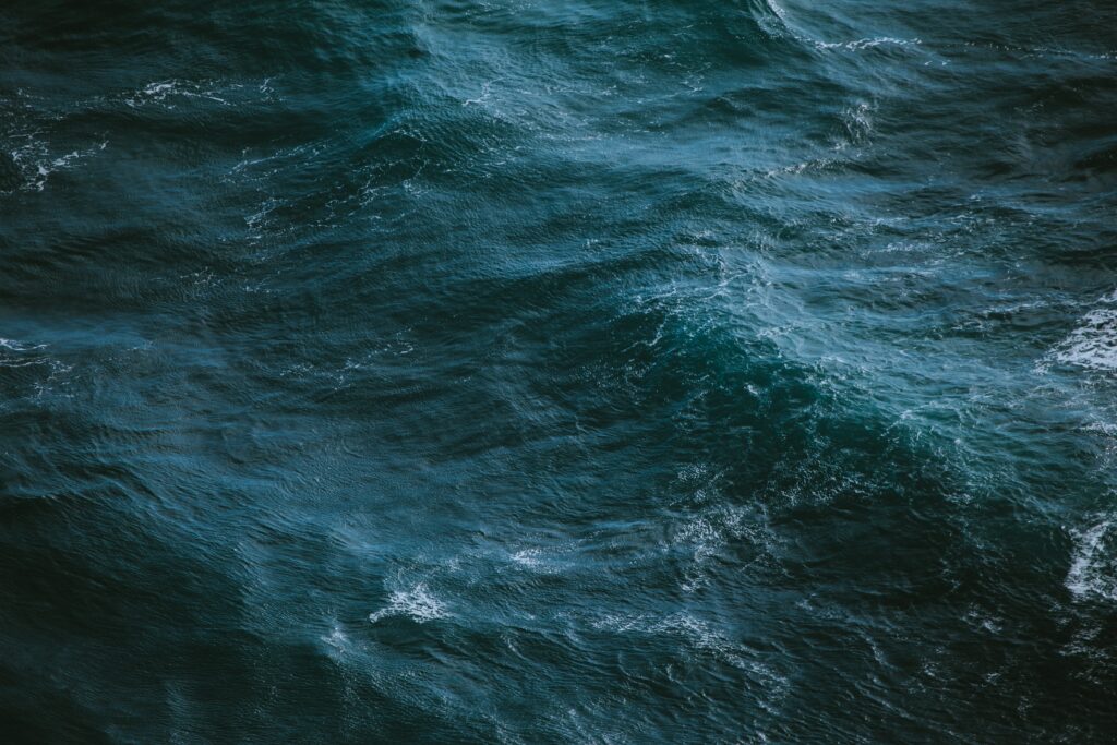 Realistic ocean surface wallpaper with deep blue waves and delicate foam patterns for calm ambiance