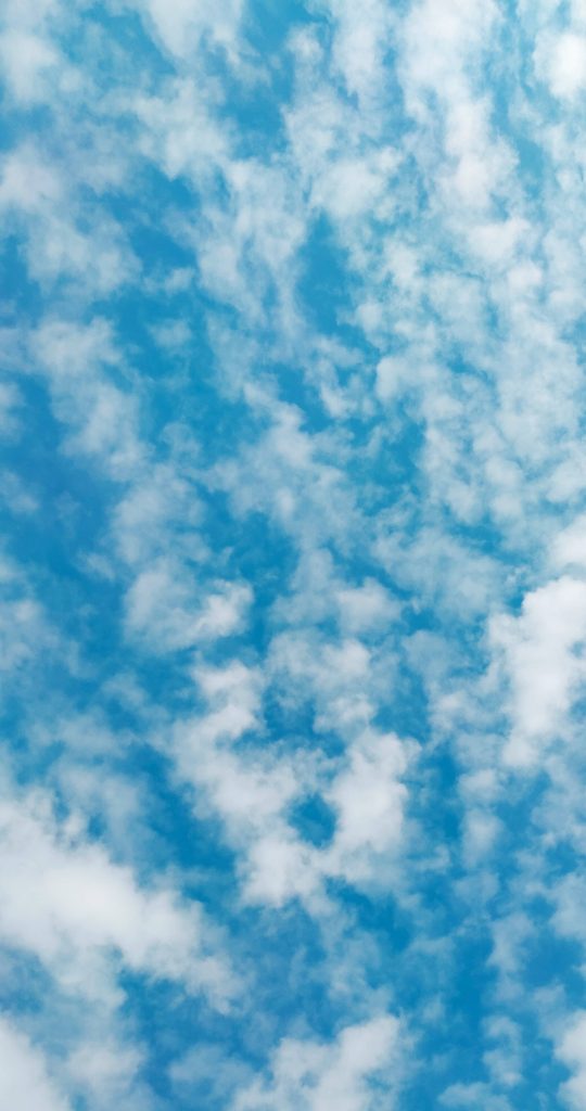 Calming blue sky wallpaper with soft white clouds minimalist bright natural background