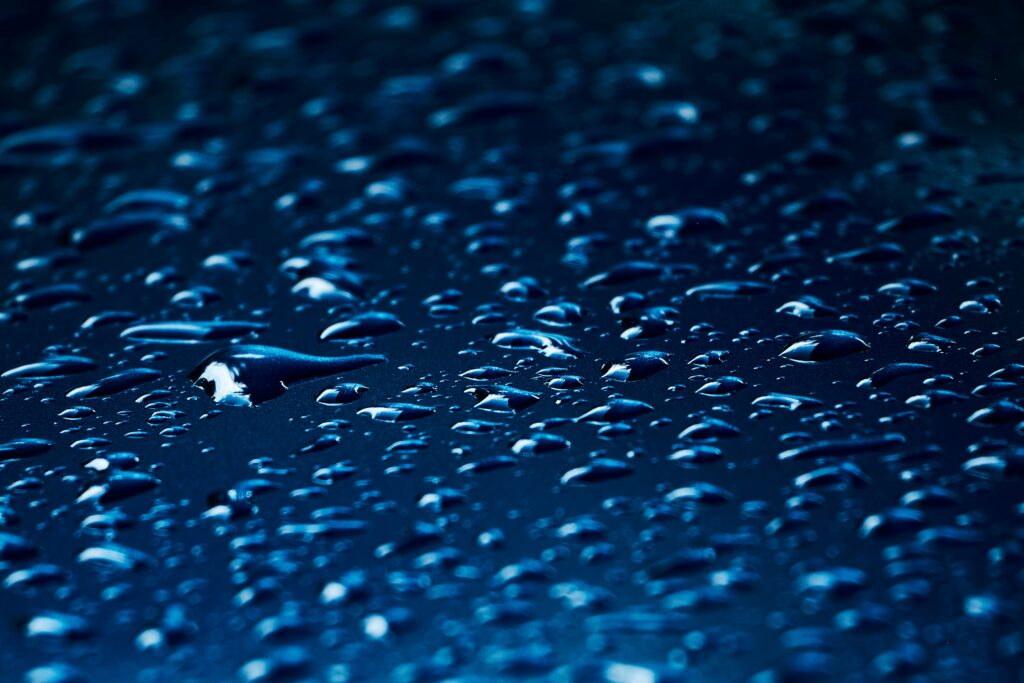Calming Blue Surface: Macro Water Droplets Wallpaper Background