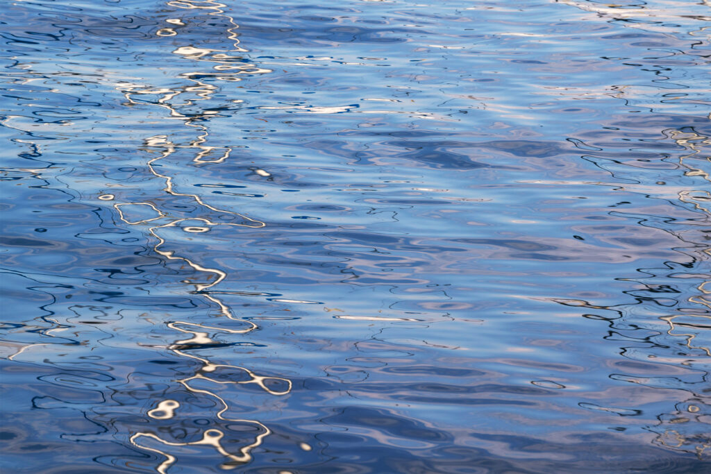 Calming blue water wallpaper with gentle ripples wavy patterns and subtle reflective glare
