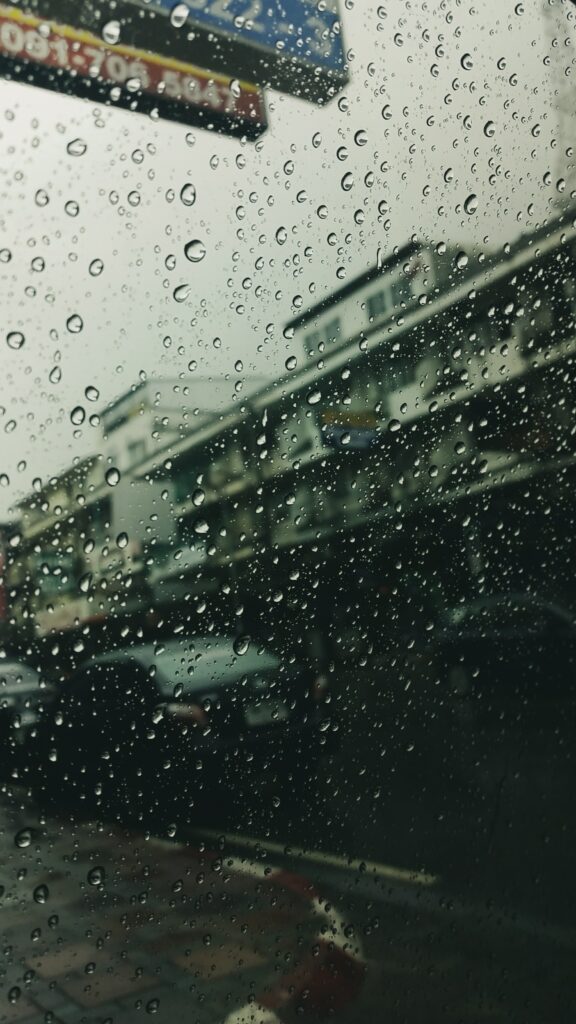 Moody Cityscape Wallpaper: Rain-Drenched Glass View