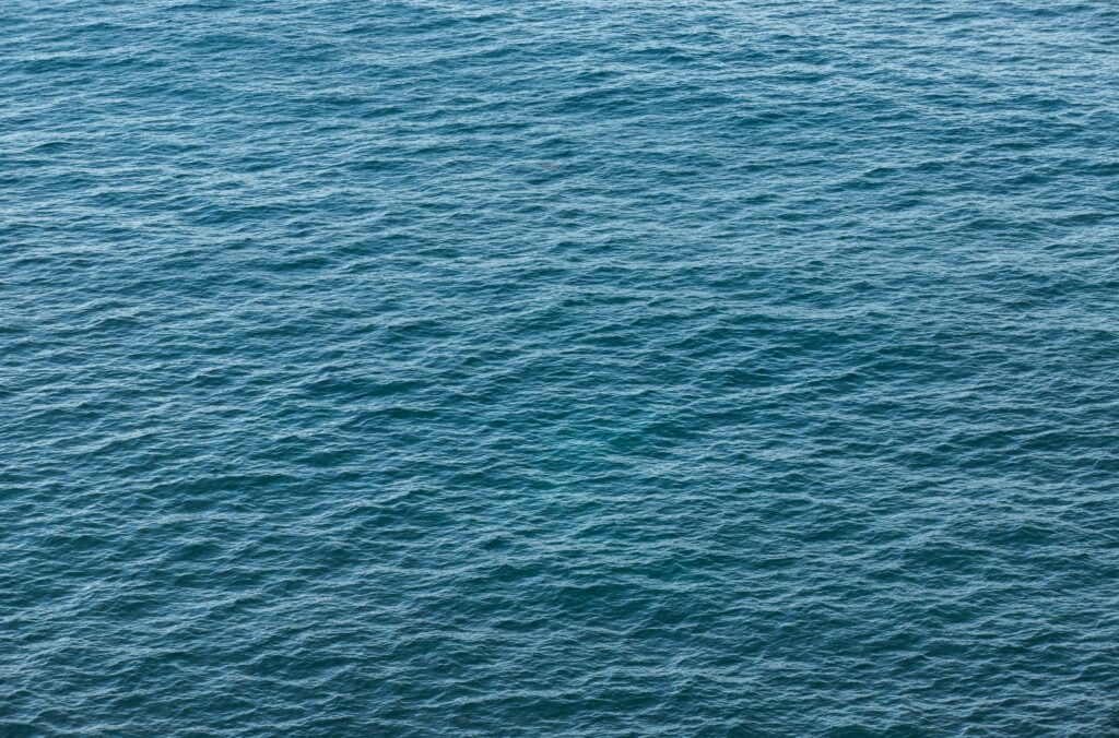 Calming open sea wallpaper with deep blue water gentle waves and natural oceanic ripples texture