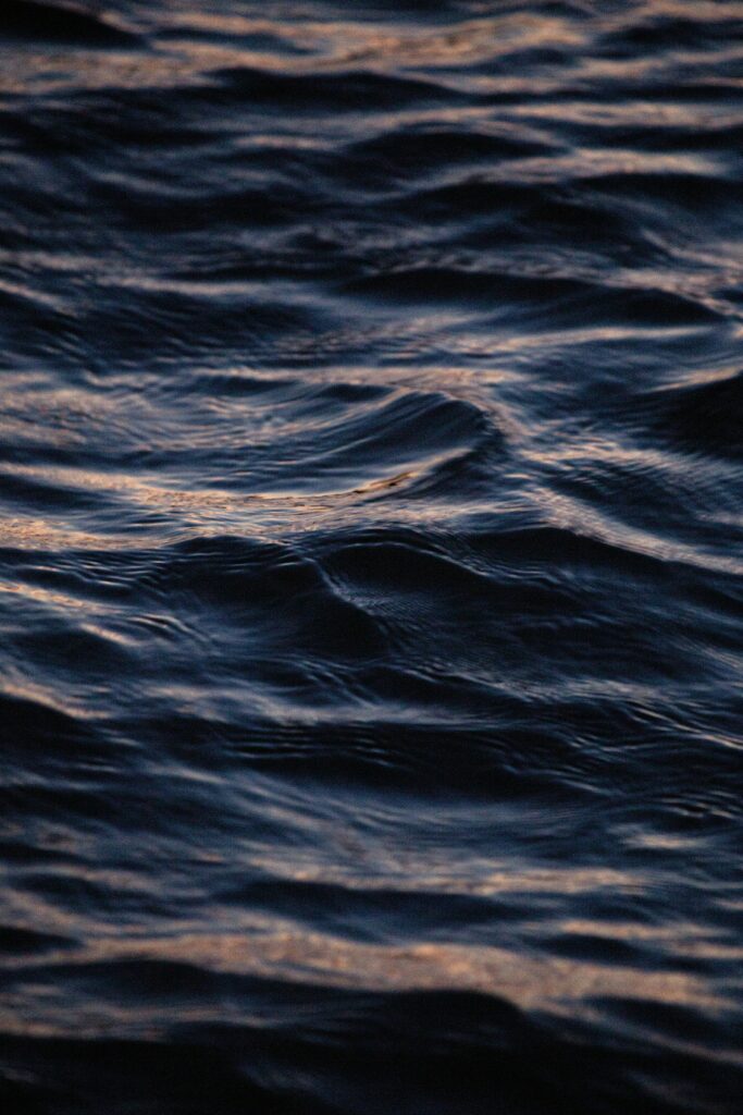 Realistic wallpaper of deep blue wavy sea with soft highlights capturing calm ocean ripples