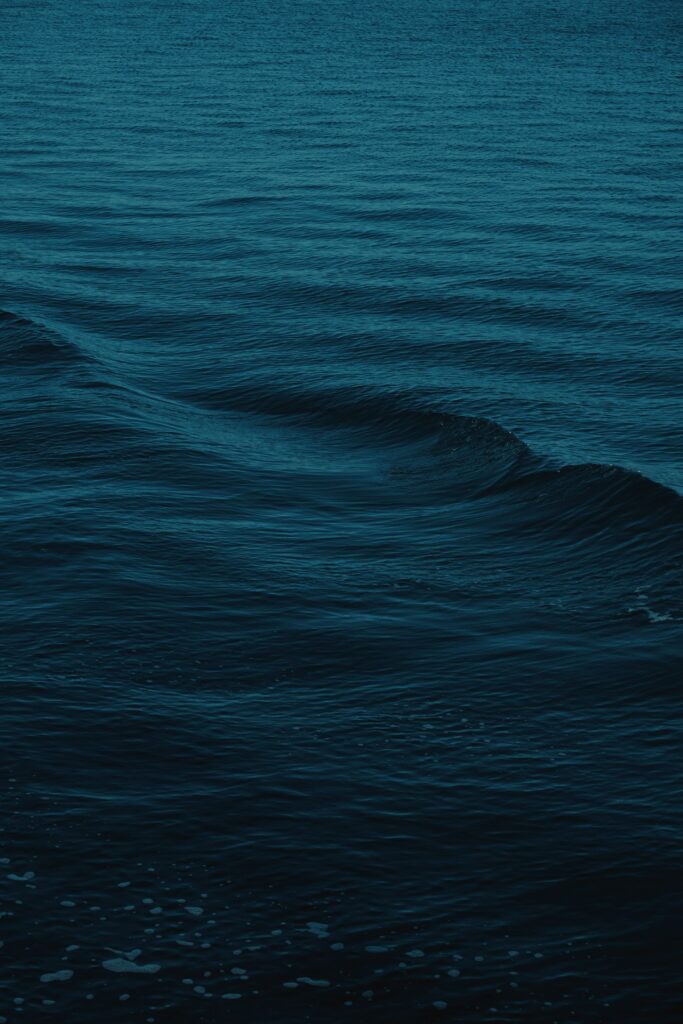 Serene deep blue ocean waves wallpaper with gentle wavy water patterns and calming minimalistic style