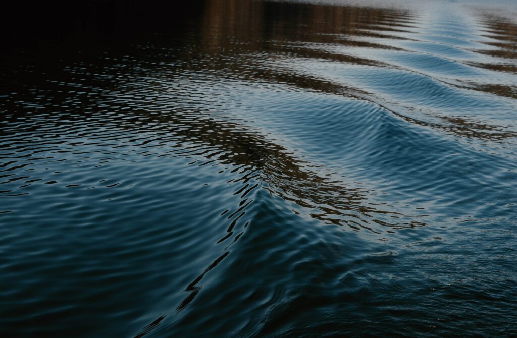 Calming deep blue sea wallpaper with gentle ripples and flowing water textures minimalist design