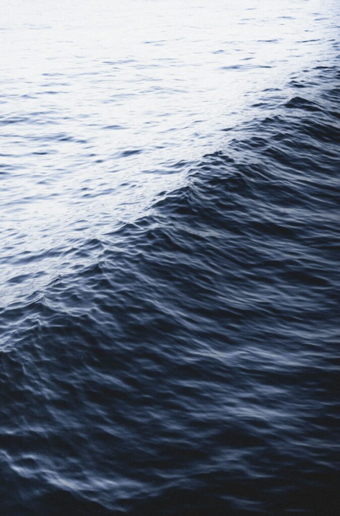 Calming sea wallpaper with gentle ripples and rolling blue and white waves background