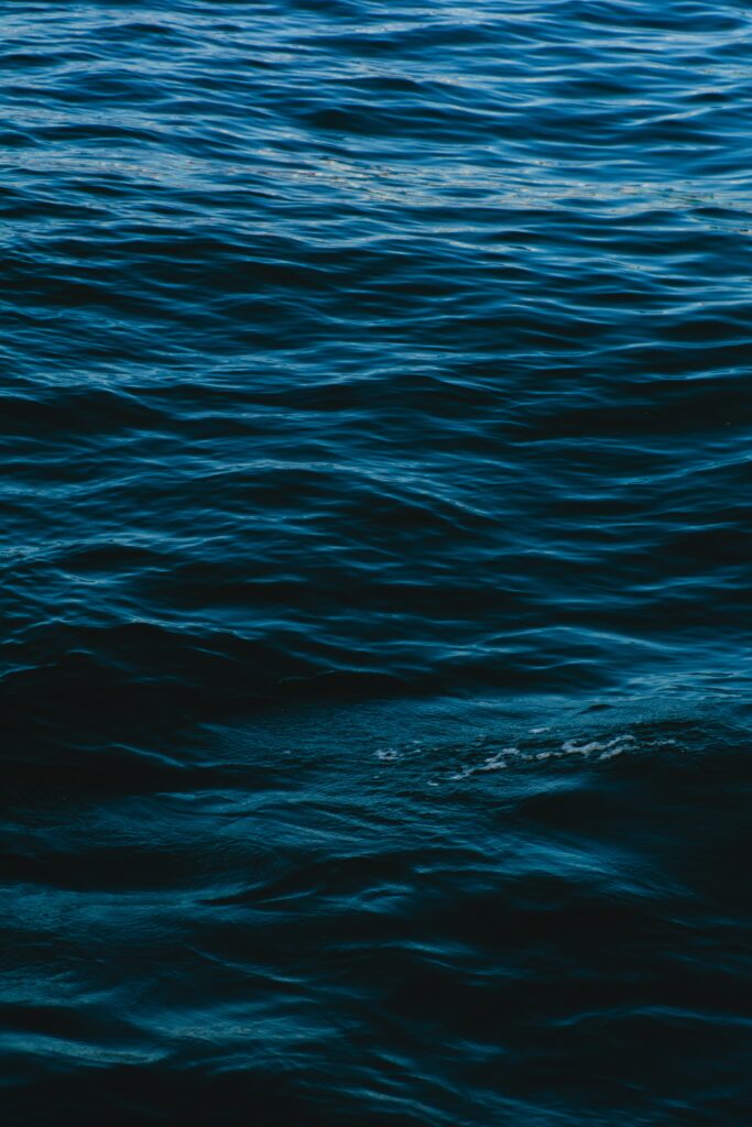 Rippling deep blue sea surface with gentle waves serene natural water texture wallpaper background