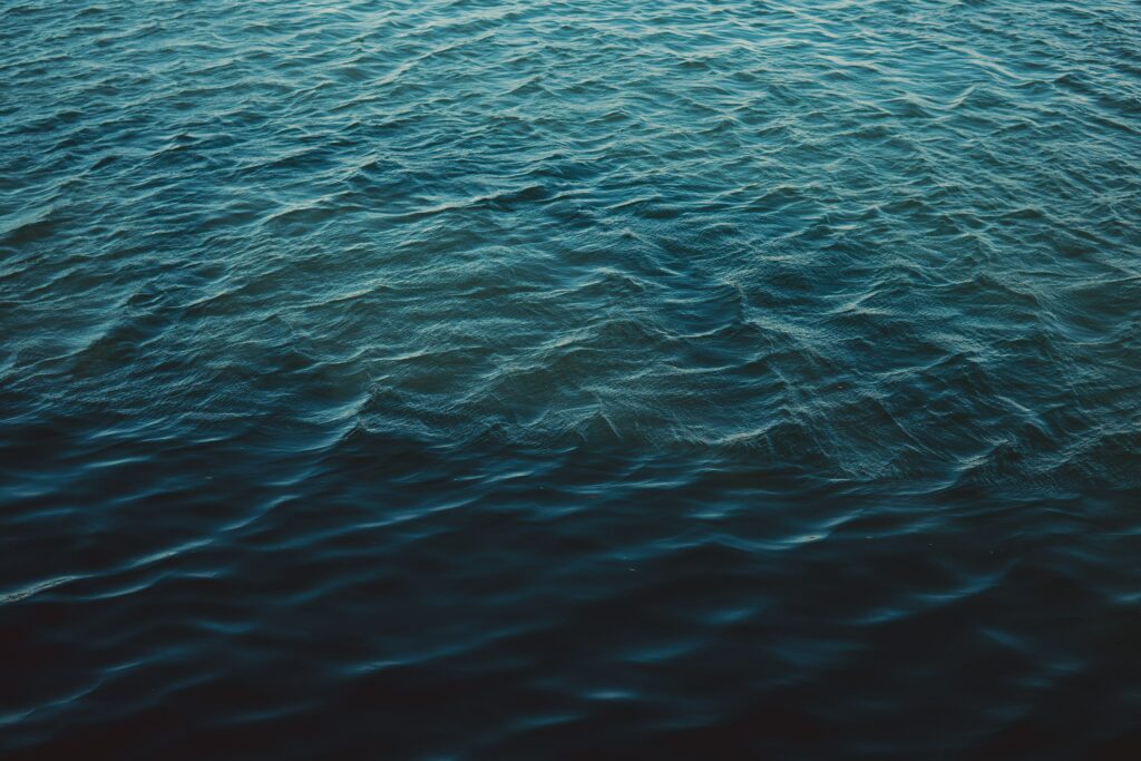 Serene deep blue sea with gentle ripples and soft reflections calming aquatic wallpaper background