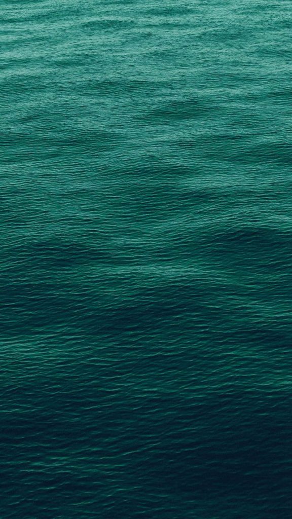 Deep emerald green water with gentle ripples serene ocean texture minimalist calming background Wallpaper