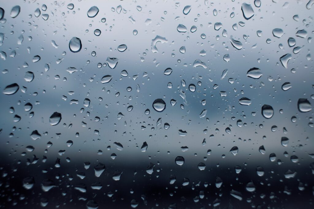 Calming Rain Droplets on Glass: Serene Macro Wallpaper Background