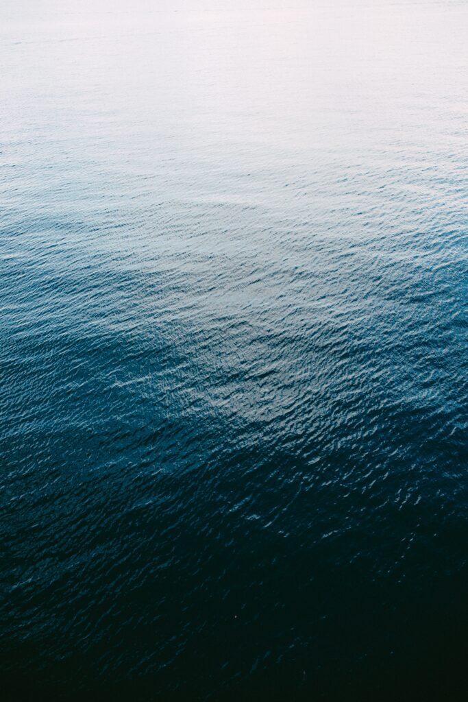 Calm ocean wallpaper with gentle ripples over vast blue water creating a serene minimalist scene