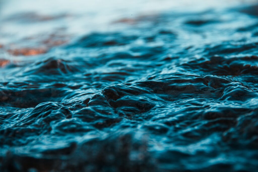 Close-up of gentle ocean waves with blue and teal ripples creating a calm seascape wallpaper