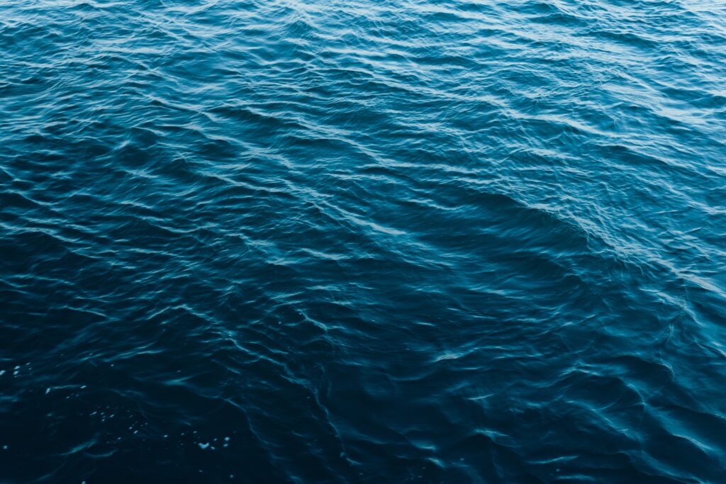 HD wallpaper of deep blue ocean with gentle ripples and calming flowing waves background