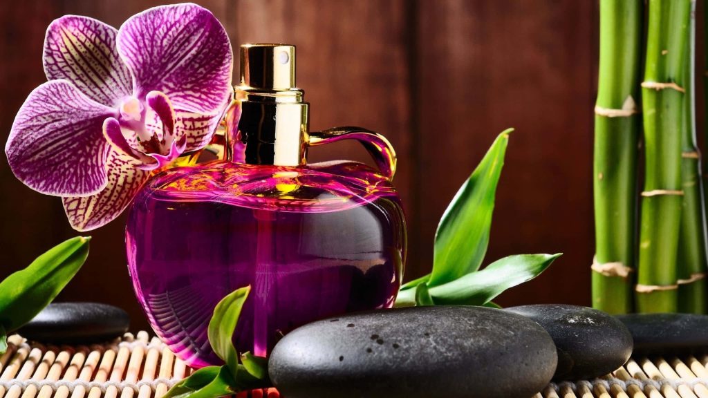 Luxurious purple perfume bottle with orchid bamboo and zen stones serene spa wallpaper background