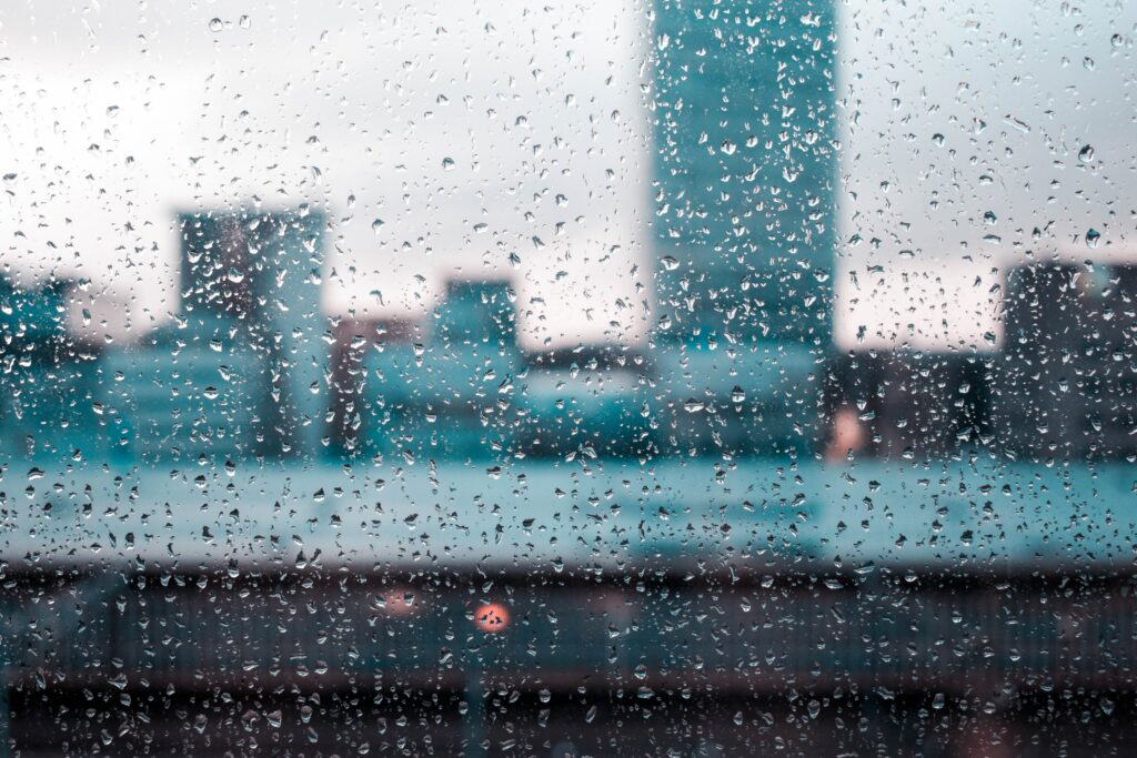 Serene Rain Droplets Wallpaper: Tranquil Glass & Cityscape Background