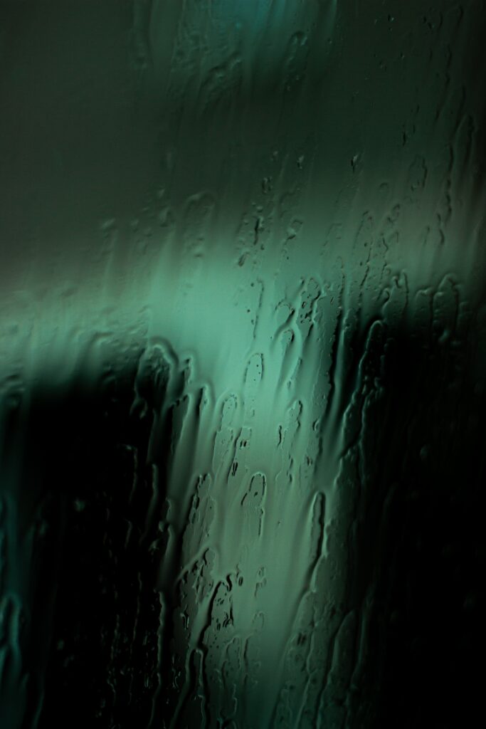 Calming Raindrops on Glass Wallpaper: Serene Green Macro Shot