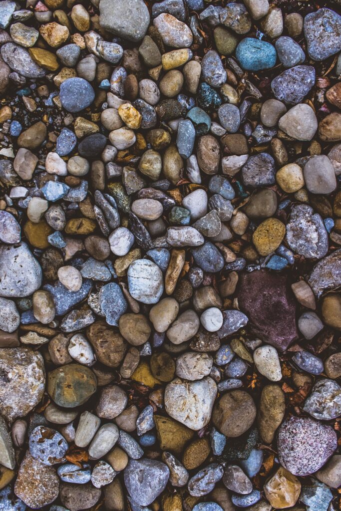 High-resolution wallpaper of smooth sea pebbles in grey brown and blue earthy tones by the seaside