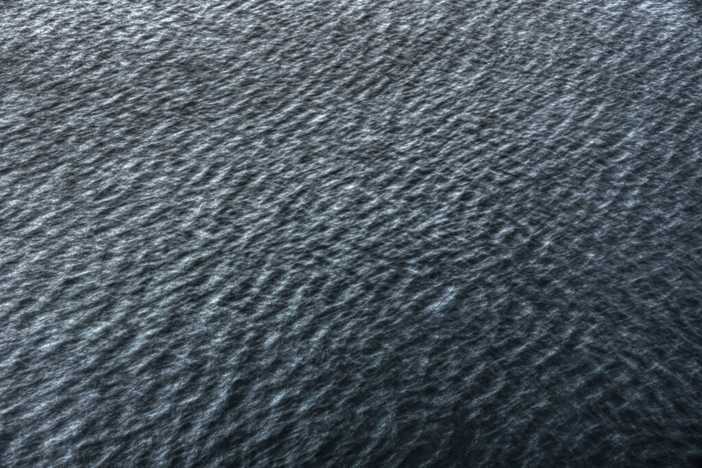 Underwater sea ripples with deep blue gray hues creating a calming textured wallpaper background