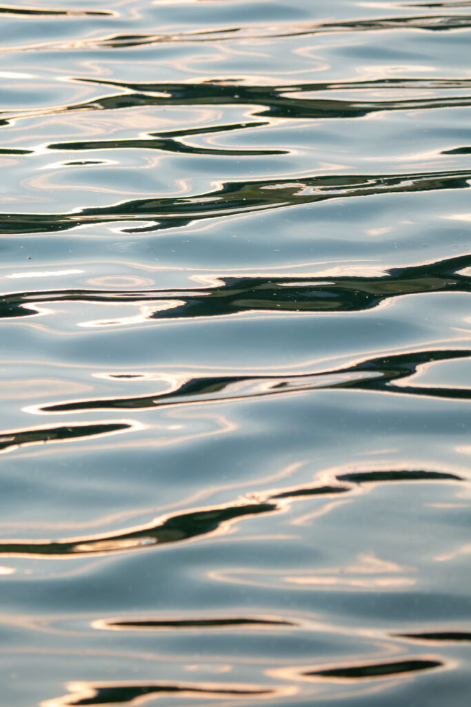 Soft water ripples reflecting sunlight on a calm serene surface nature wallpaper background