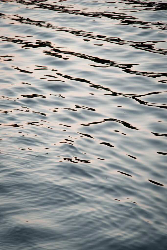 Calming water surface with gentle ripples soft natural light abstract serene wallpaper background