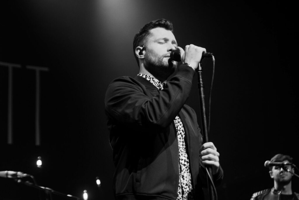 Calum Scott live concert black and white wallpaper dramatic lighting expressive stage performance