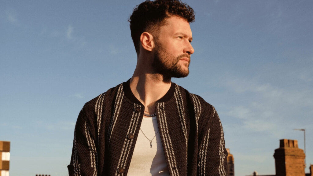 British singer Calum Scott outdoors warm natural light blue sky contemplative expression Wallpaper