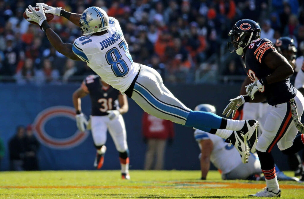 Calvin Johnson mid-air diving catch Detroit Lions 81 jersey vibrant stadium football action wallpaper