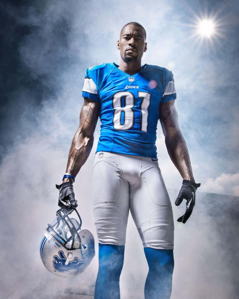 Calvin Johnson in Detroit Lions number 81 jersey holding helmet smoky background NFL star wallpaper
