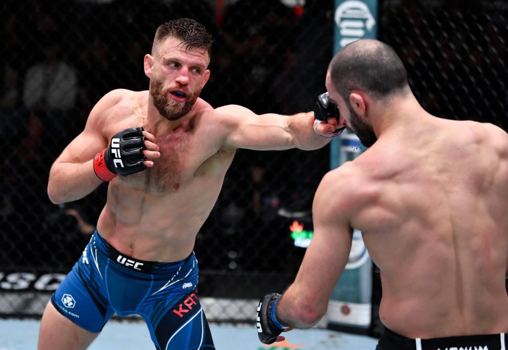 Calvin Kattar delivering a powerful punch to Giga Chikadze in UFC Octagon fight action Wallpaper
