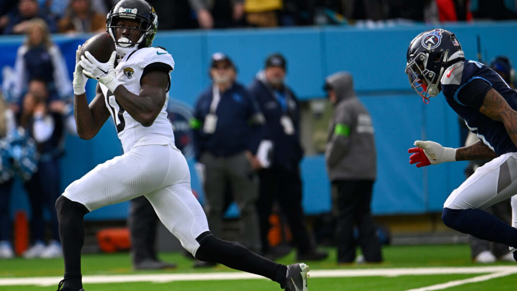 Calvin Ridley catching football in Jacksonville Jaguars uniform during intense game play on field Wallpaper