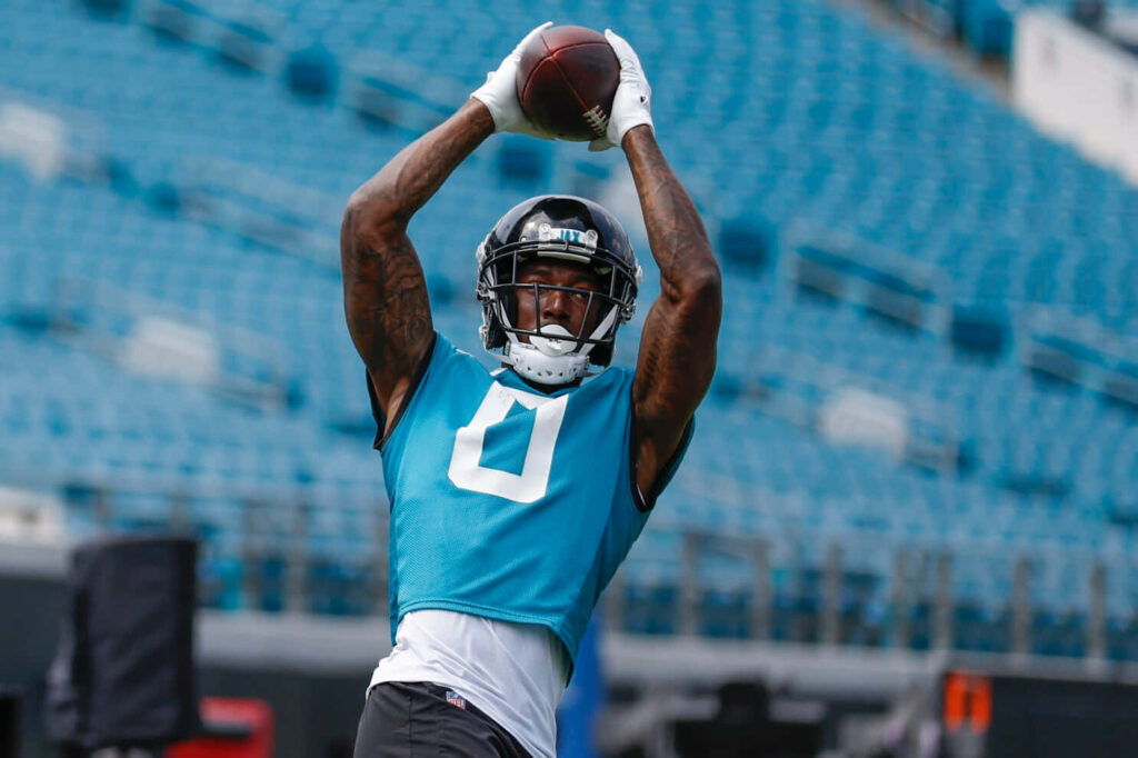 Calvin Ridley catching football during practice in helmet and teal vest with blue stadium seats Wallpaper