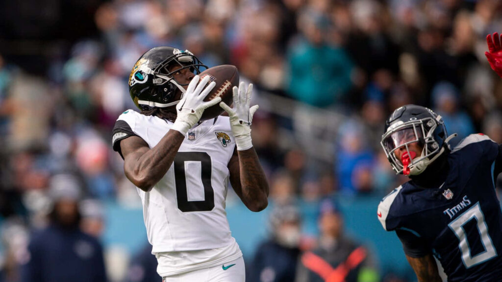 Calvin Ridley catching football mid-air in white Jaguars uniform during intense game action Wallpaper