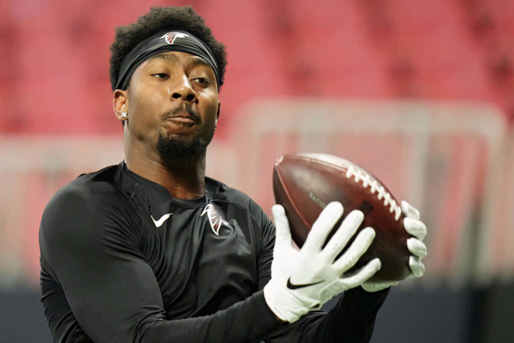Calvin Ridley intense catch drill Falcons training vibrant energy black gear red stadium background Wallpaper