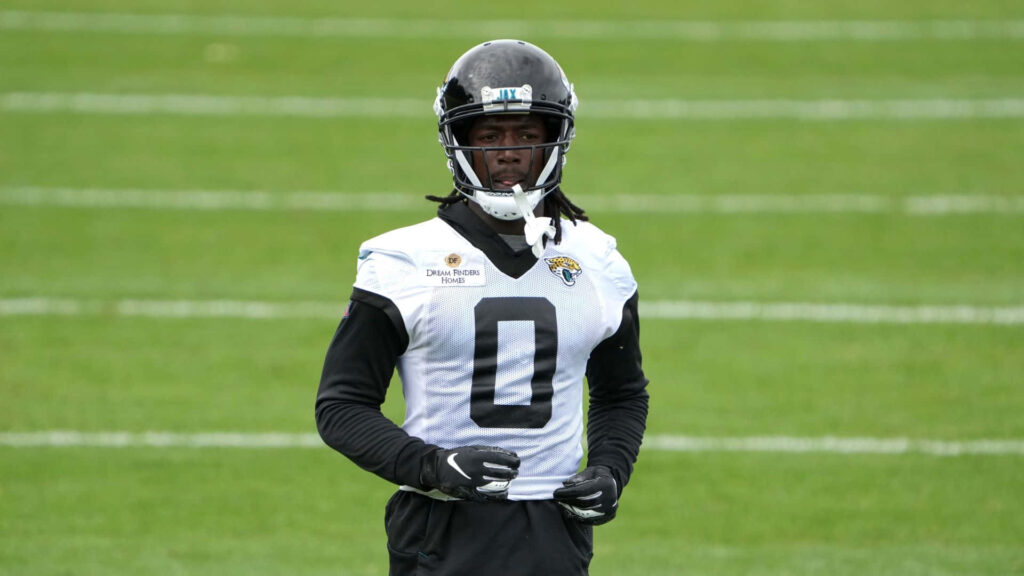 Calvin Ridley in Jacksonville Jaguars uniform focused on green football field during practice Wallpaper