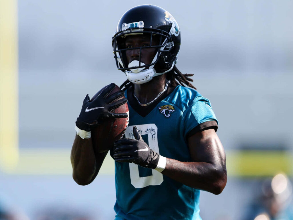 Calvin Ridley in Jacksonville Jaguars teal uniform mid-practice holding football outdoor wallpaper