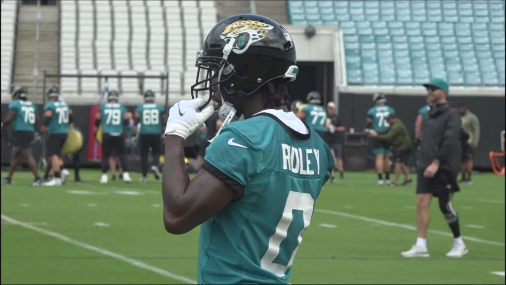 Calvin Ridley focused in teal Jaguars gear during intense football training session on field Wallpaper