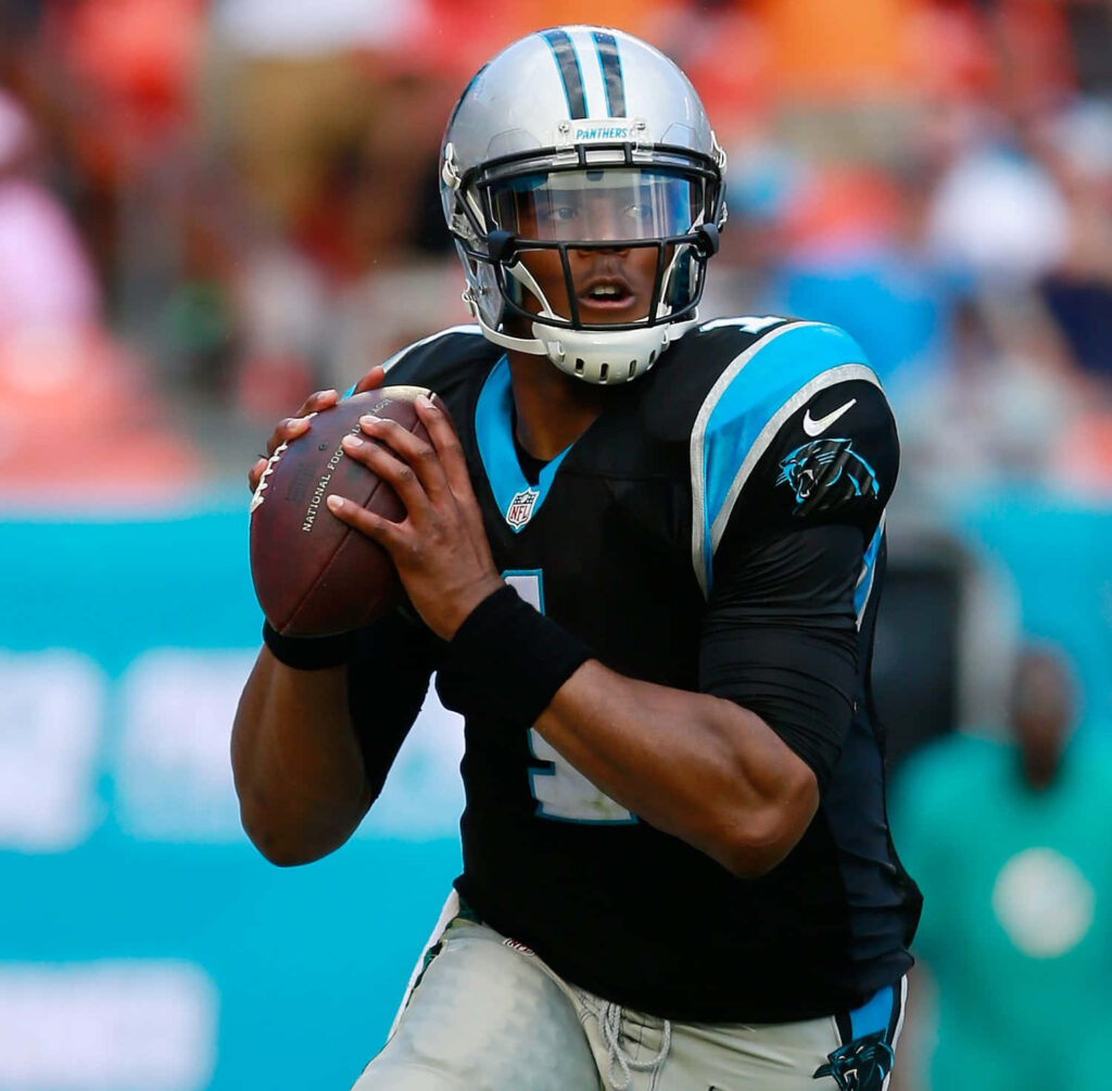 Cam Newton Carolina Panthers quarterback mid-play intense focus vivid stadium action wallpaper