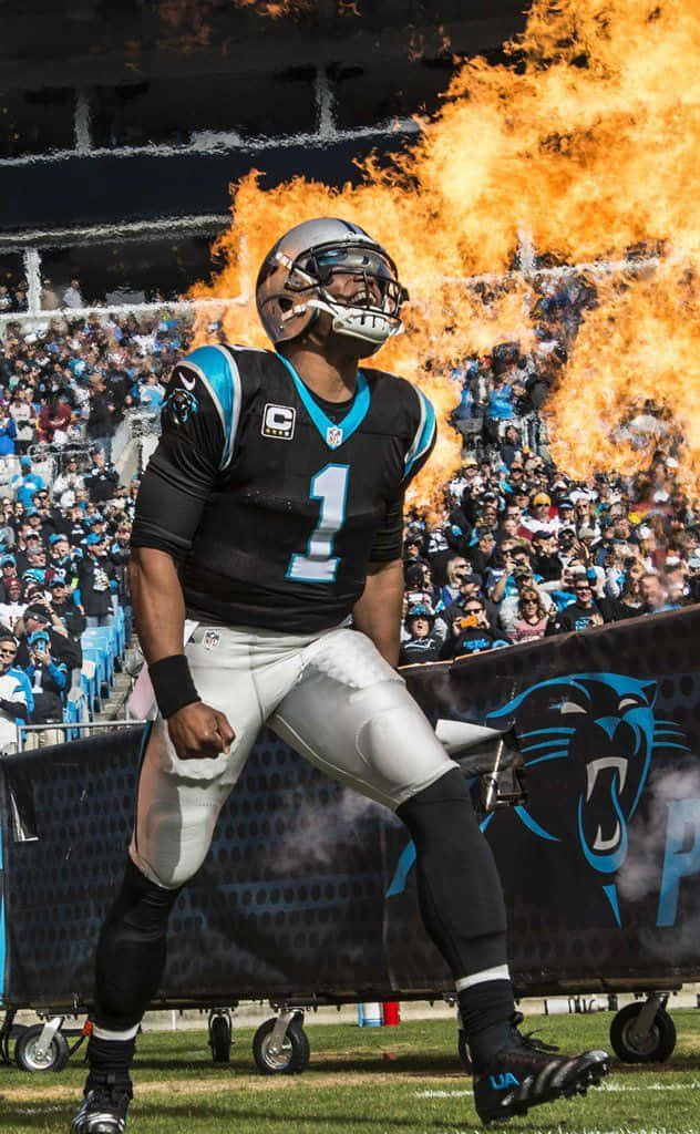 Cam Newton celebrates touchdown in Carolina Panthers uniform with roaring flames and crowd background Wallpaper