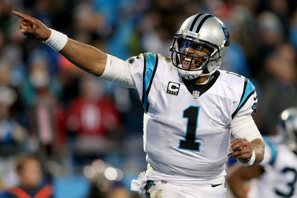 Cam Newton pointing in Carolina Panthers uniform during intense NFL game action wallpaper background