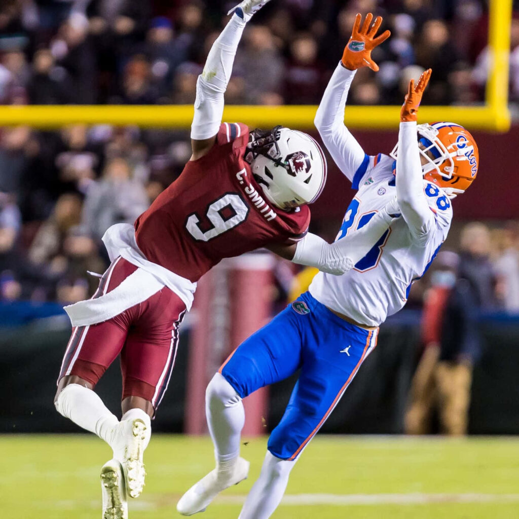 Cam Smith college football action contesting pass vibrant maroon white uniform intense game Wallpaper