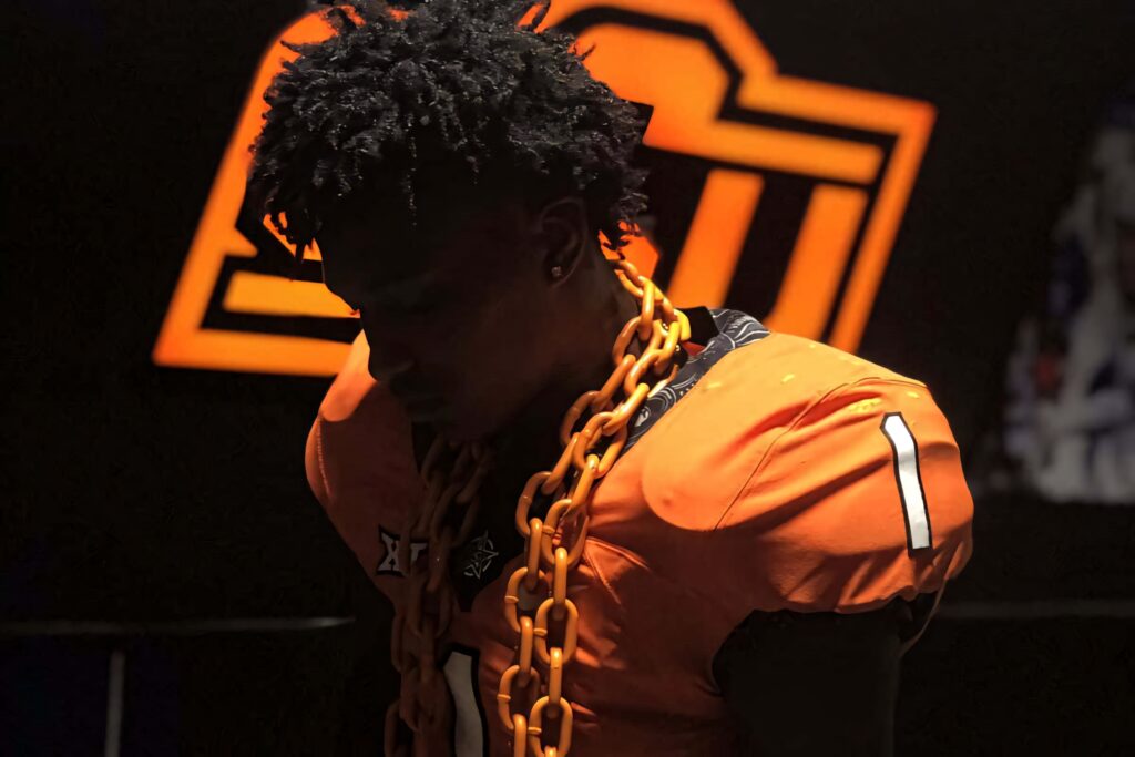 Cam Smith in vibrant orange jersey with bold chain against dark background sports wallpaper