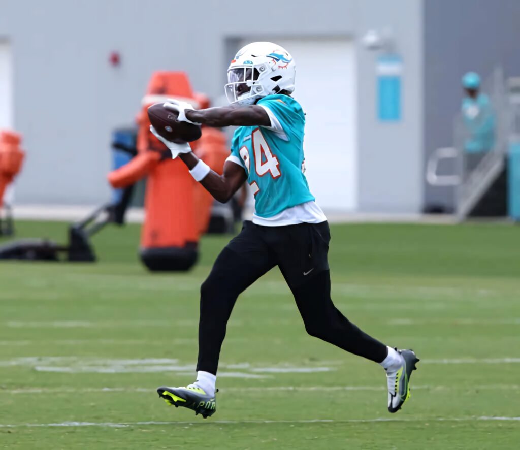 Cam Smith catching football during Miami Dolphins practice in teal jersey on green field Wallpaper